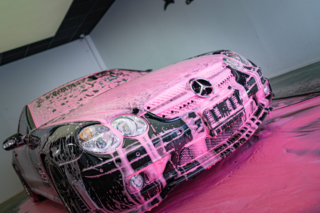 Mercedes Cabrio coated in pink purple foam during auto car detailing